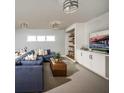 Cozy living room featuring a comfortable blue sofa, modern lighting, and built-in shelving at 9429 Golden Laurel Ln, Orlando, FL 32827
