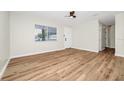 Bright living room showcasing new wood floors, modern ceiling fan, fresh paint and ample natural light at 4710 Hatteras Ct, Orlando, FL 32808