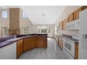 Spacious kitchen featuring light wood cabinets, white appliances, and a breakfast bar overlooking the dining area at 11160 Sylvan Pond Cir, Orlando, FL 32825