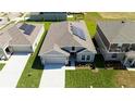 An aerial view shows solar panels on the roof of a modern home with manicured lawns at 1163 James Paul Rd, Davenport, FL 33837