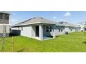 The backyard has a covered patio, green grass and simple landscaping at 1163 James Paul Rd, Davenport, FL 33837