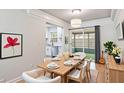 Bright dining area featuring modern lighting and direct access to a sunroom and kitchen at 125 E Miller St, Orlando, FL 32806