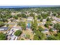 An aerial view of a single-Gathering home surrounded by lush greenery and a glimpse of the nearby bay at 131 Autumn Ct, St Cloud, FL 34771