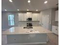 Bright kitchen featuring white cabinets, stainless steel appliances, and a large center island at 1360 Twelve Oaks Rd, St Cloud, FL 34771
