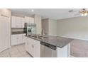 Modern kitchen with granite island, stainless steel appliances, and white cabinetry, seamlessly flowing into living area at 14066 Sw 60Th Ter, Ocala, FL 34473