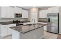 Bright kitchen featuring granite countertops, stainless steel appliances, and ample storage in white cabinets at 14066 Sw 60Th Ter, Ocala, FL 34473