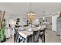 Dining area features modern chandelier, decor, and views into the kitchen and living spaces at 149 Hickory Course Cir, Ocala, FL 34472