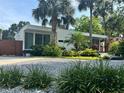 A modern home with lush landscaping, a well-manicured lawn, and gravel driveway for added curb appeal at 1634 Hull Cir, Orlando, FL 32806