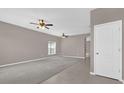 Bright living space featuring large windows, carpet, tile flooring, and a ceiling fan, creating a welcoming atmosphere at 1730 Ribbon Falls Pkwy, Orlando, FL 32824