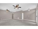 Open-concept living area with tile and carpet flooring, ceiling fans, and neutral paint, offering versatility at 1730 Ribbon Falls Pkwy, Orlando, FL 32824