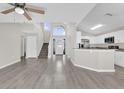 Bright living room with modern gray floors, a staircase, and an adjacent kitchen area at 1851 Wimbledon St, Kissimmee, FL 34743