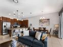 Open-concept living area with tile flooring, modern lighting, and a kitchen island with seating at 193 Captiva Dr, Davenport, FL 33896