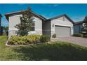 Charming single-story home with a manicured lawn, brick driveway, and two-car garage at 2168 Marsh Sedge Ln, Winter Park, FL 32792