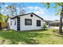 Side view of a charming home featuring a well-manicured lawn and a well-maintained exterior, nestled amongst mature trees at 2412 Yule Tree Dr, Edgewater, FL 32141