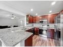 Modern kitchen featuring stainless steel appliances, granite countertops, and wood-style flooring at 284 Talladega Ln, Polk City, FL 33868