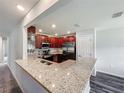 Open kitchen with granite countertops, stainless steel appliances, and dark wood cabinets at 284 Talladega Ln, Polk City, FL 33868