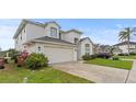 Charming two-story home with a spacious driveway and well-kept lawn and landscaping at 2889 Blooming Alamanda Loop, Kissimmee, FL 34747