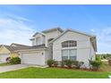 Beautiful two-story home with an attached garage and well-maintained green lawn at 2889 Blooming Alamanda Loop, Kissimmee, FL 34747