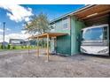 Metal barn with a large RV parked inside, and an overhanging porch with seating area outside at 4640 Hickory Tree Rd, St Cloud, FL 34772