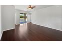 Spacious living room with hardwood floors and sliding glass doors leading to a patio at 4841 Hickory Stream Ln, Mulberry, FL 33860