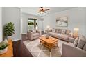 Comfortable living room with dark wood floors, neutral colors, and large windows with beautiful views at 4841 Hickory Stream Ln, Mulberry, FL 33860