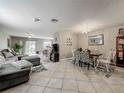 Open-concept living and dining area with stylish furnishings and tile floors at 5050 Shorewood Landing Ln, Oviedo, FL 32765
