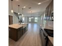 Open kitchen and living area with an island, pendant lighting, and stainless steel appliances at 5330 Center Lake, St Cloud, FL 34771