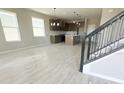 Living room with wood-look tile floors, kitchen view, and a modern staircase at 5330 Center Lake, St Cloud, FL 34771