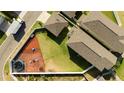 Aerial view of a property showcasing a fenced backyard with grass, play areas, trampoline and a lush garden at 10038 Verse Aly, Winter Garden, FL 34787