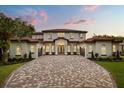 Imposing two-story home featuring a tile roof, arched windows, and a paver driveway at 11019 Kentmere Ct, Windermere, FL 34786
