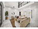 Bright living room with soaring ceilings, marble floors, and stylish modern decor at 11019 Kentmere Ct, Windermere, FL 34786