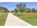 Long, paved driveway leading to the house, surrounded by green lawns and a wooden fence at 1271 Thoroughbred Trl, Sanford, FL 32771