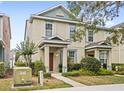 Inviting two-story townhome with neutral paint, decorative shutters, and manicured landscaping at 12977 Borland St, Windermere, FL 34786