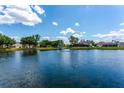 Picturesque view of a tranquil lake with a fountain, surrounded by lush greenery and beautiful homes at 13111 Meergate Cir, Orlando, FL 32837