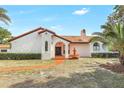 Charming Spanish-style home with a terracotta roof, water fountain, arched doorway and lush landscaping at 13124 Filly Ct, Windermere, FL 34786