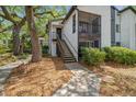 Two-story condo building with outdoor balcony, stairwell access, and mature trees at 150 Waterfall Way # 102, Altamonte Springs, FL 32714