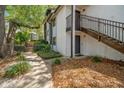Exterior view of a two-story condo building with stairwell access and lush landscaping at 150 Waterfall Way # 102, Altamonte Springs, FL 32714