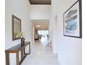 Bright entryway featuring tile floors, high ceilings, a wood table, artwork, and views of the dining area at 1663 Lima Ave, Kissimmee, FL 34747