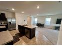 Spacious kitchen with stainless steel appliances, center island, and adjacent dining area at 1800 Post Oak Dr, Davenport, FL 33837