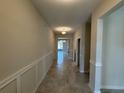 Inviting hallway with neutral paint, white trim, and ceramic tile flooring throughout main living area at 18219 Oliver Twist Way, Winter Garden, FL 34787