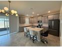 Modern kitchen with granite countertops, a spacious island, stainless appliances and gray wood cabinetry at 18219 Oliver Twist Way, Winter Garden, FL 34787