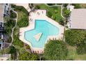 Aerial view of a unique, geometric-shaped pool surrounded by lush landscaping and lounge chairs at 200 Maitland Ave # 224, Altamonte Springs, FL 32701