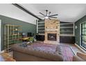 Cozy living room featuring brick fireplace, built-in shelving, and an oversized ceiling fan at 203 E Greentree Ln, Lake Mary, FL 32746