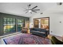 Comfortable living room with large windows, a stylish tufted sofa, and a decorative rug at 203 E Greentree Ln, Lake Mary, FL 32746