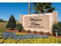 Windsor Palms community sign features a beautiful stone design, flowers, and landscaping at 2302 Butterfly Palm Way # 105, Kissimmee, FL 34747