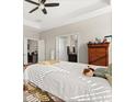 Comfortable main bedroom featuring a tray ceiling, ceiling fan, and ensuite bathroom access at 2405 Standing Rock Cir, Oakland, FL 34787