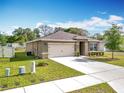 Attractive single-story home with green lawn, clean driveway, and an attached two-car garage at 2636 Grand Central Ave, Tavares, FL 32778