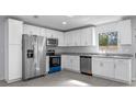 Modern kitchen features stainless steel appliances, granite counters, and white cabinets at 2763 E Waco Dr, Deltona, FL 32738
