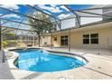 Backyard pool with screen enclosure, patio area, and views of neighboring houses and blue skies in the background at 2995 White Magnolia Loop, Clermont, FL 34711