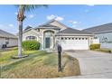 Charming single-story home featuring a two-car garage, a well-maintained lawn, and mature landscaping, providing excellent curb appeal at 314 Lady Diana Dr, Davenport, FL 33837